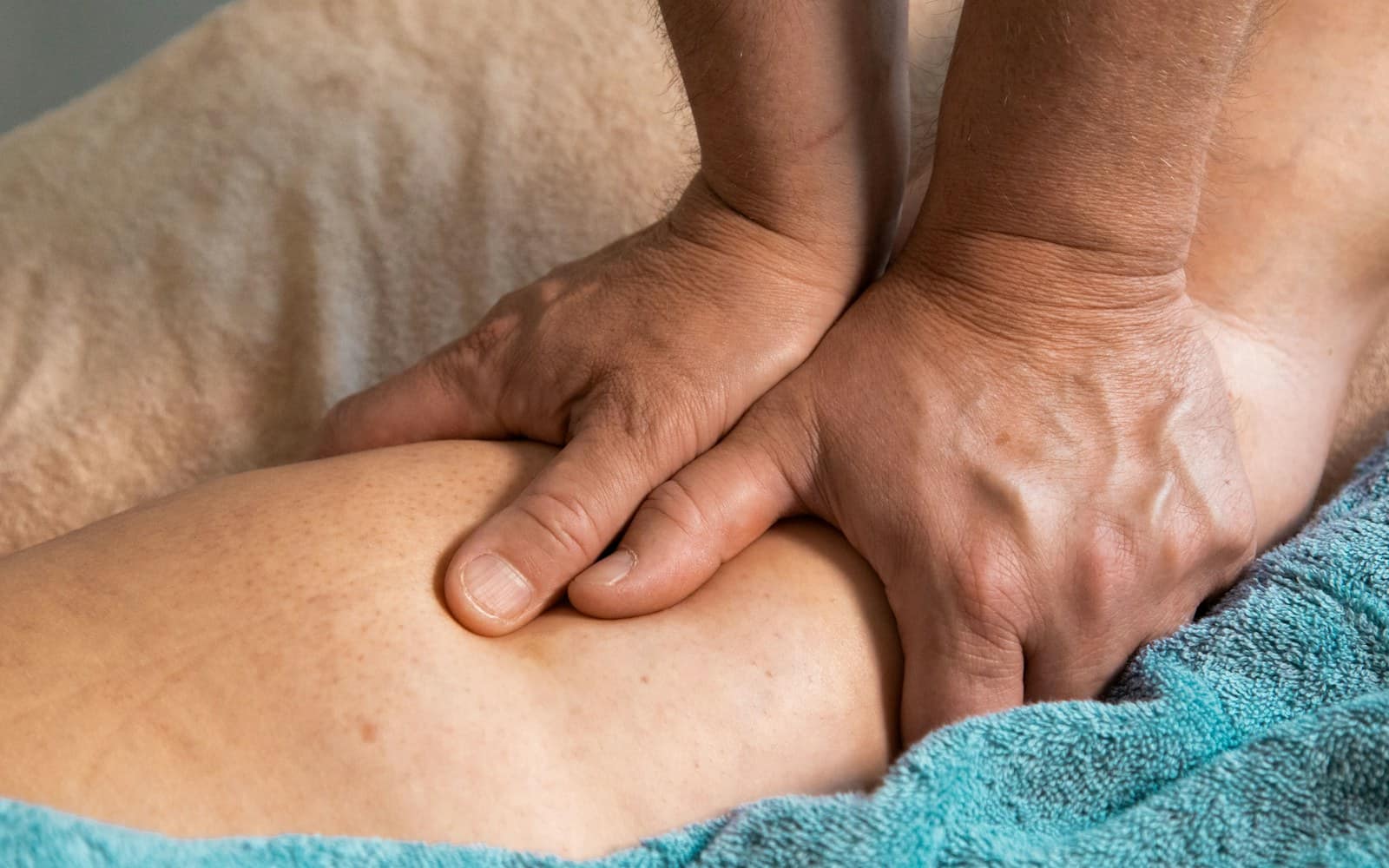 A professional massage therapist working with both hands during a home session A professional massage therapist working with both hands during a home session