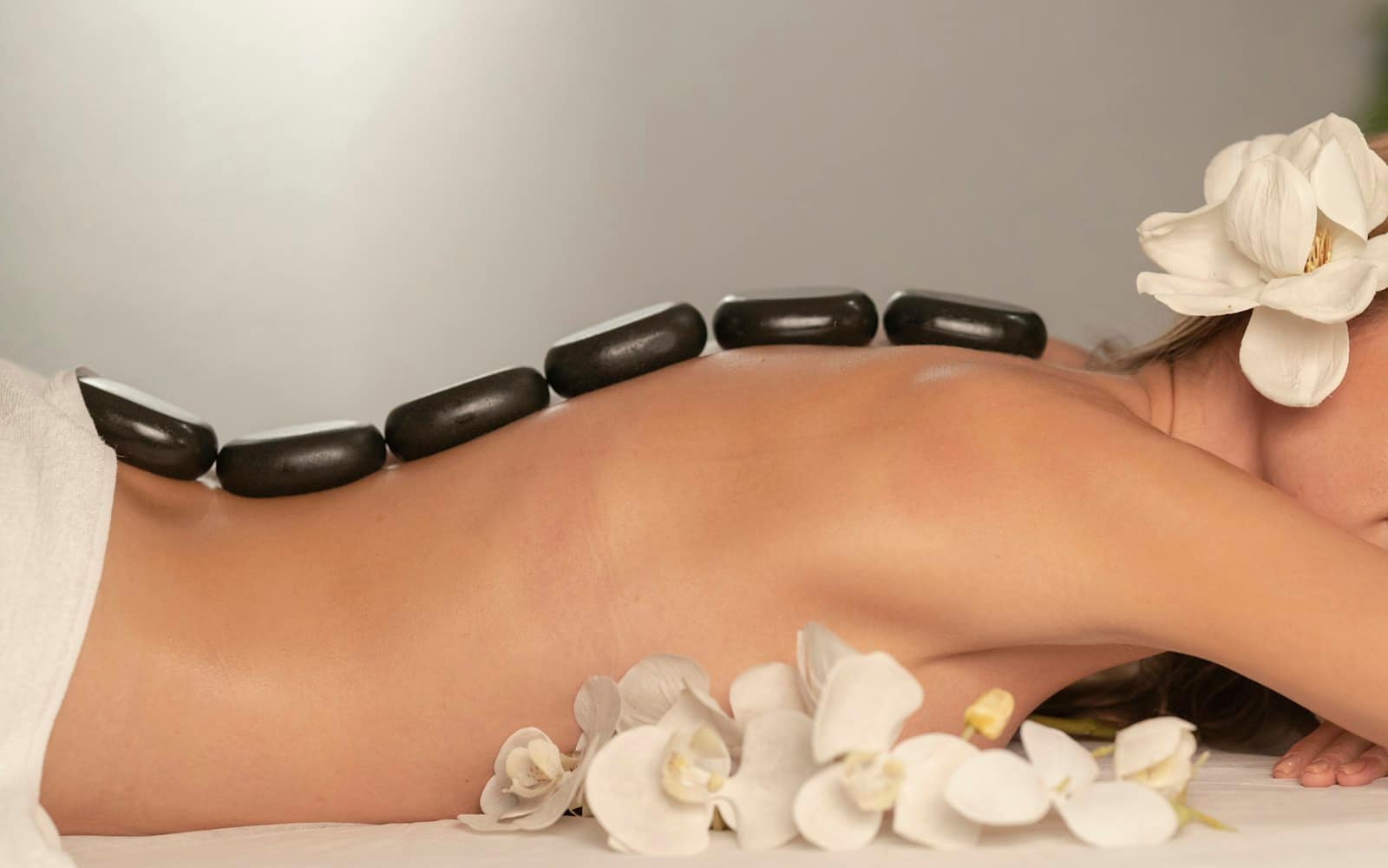 Hot stones placed along the back during a massage treatment Hot stones placed along the back during a massage treatment